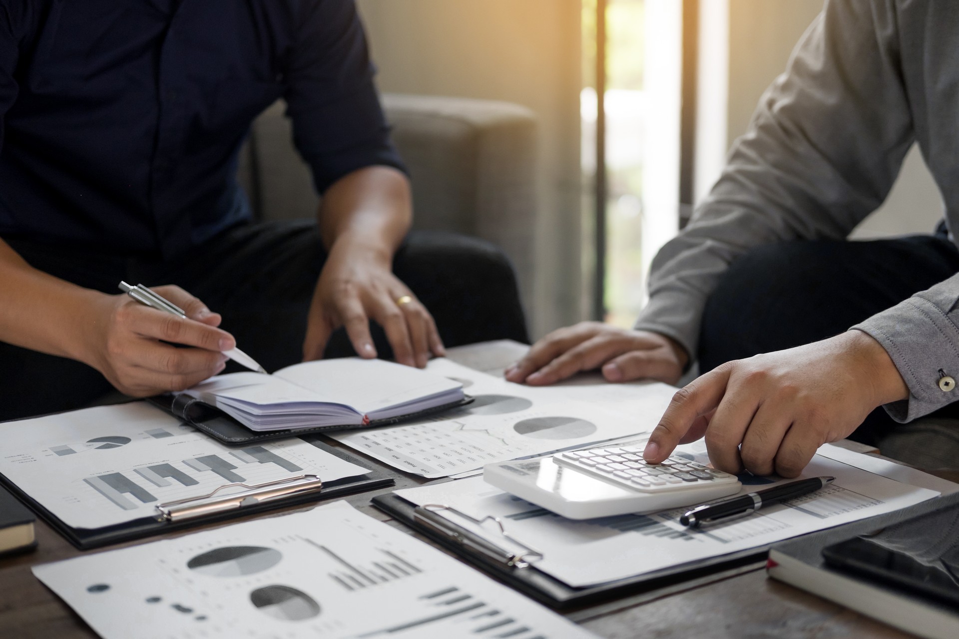 Sección media de hombres de negocios haciendo papeleo en la oficina
